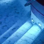 Two underwater lights illuminating the steps into a pool.